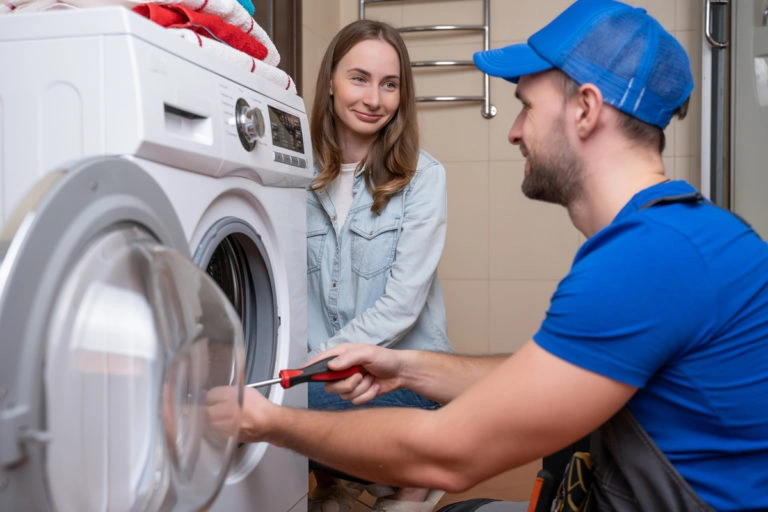Technik opravuje pračku, která může být příčinou hluku.