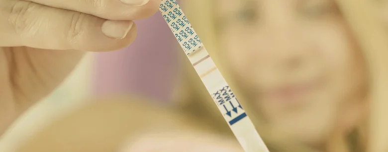 Pregnancy test strip held by hand