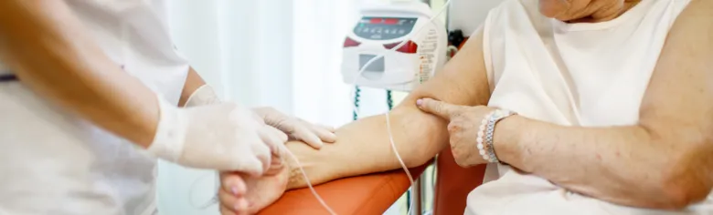 Sestra odebírá krev pacientovi během chemoterapie.