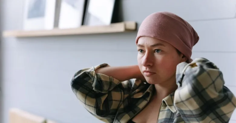 Žena v kšiltovce s myšlenkami o účincích chemoterapie.