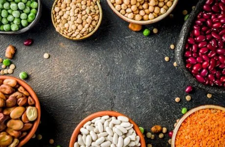 Různé druhy luštěnin a obilovin vhodné do veganské stravy.
