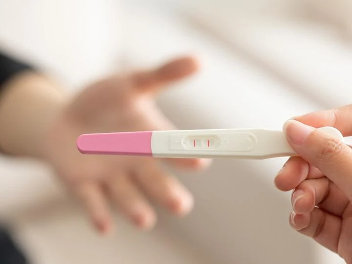 Těhotenský test s dvěma čarami ukazující pozitivní výsledek.