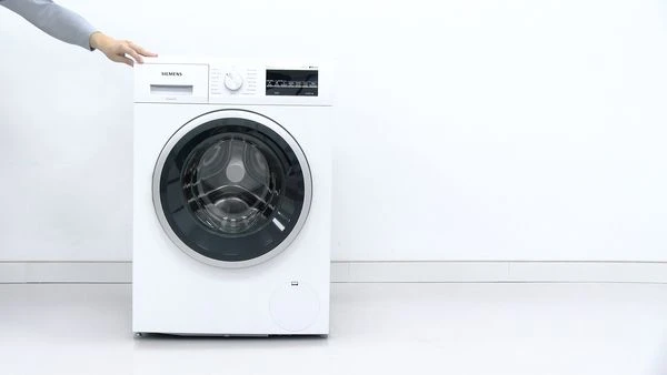 Bílá pračka značky Siemens na čistém pozadí.