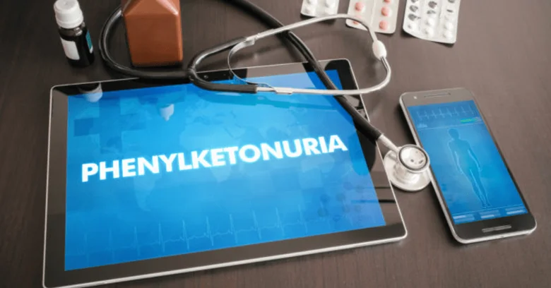 Tablet s textem fenylketonurie ležící mezi lékařskými předměty.