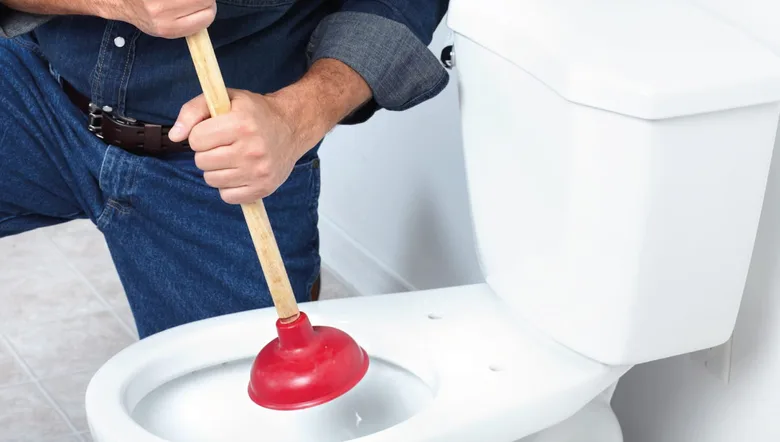 Muž používá hadicovou pumpu na záchod.
