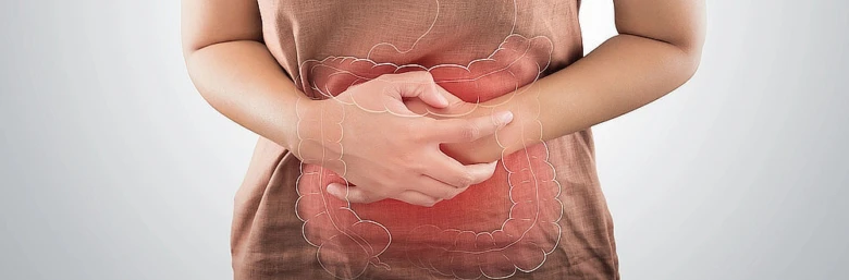 Žena drží břicho s přehnutím tlustého střeva ukazujícími příznaky zánětlivých onemocnění.