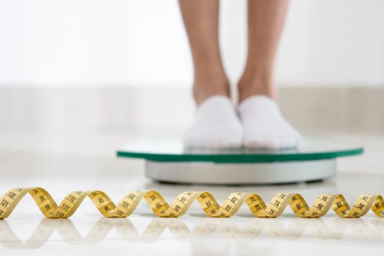 Person on scale with tape measure