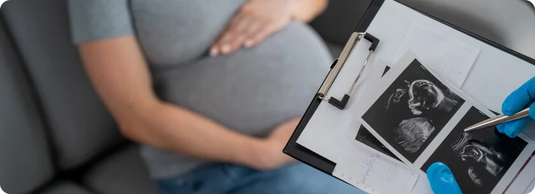 Těhotná žena s ultrazvukem na tabuli pro články o těhotenství.
