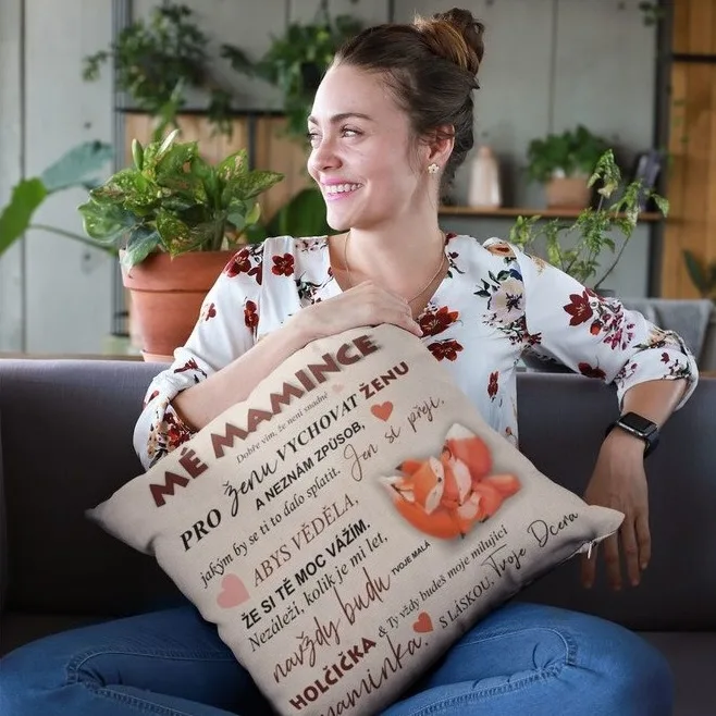 Žena drží polštář s českým textem pro maminku a dítě