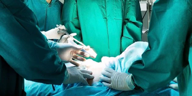 Chirurgové operují pacienta v nemocničním sále.