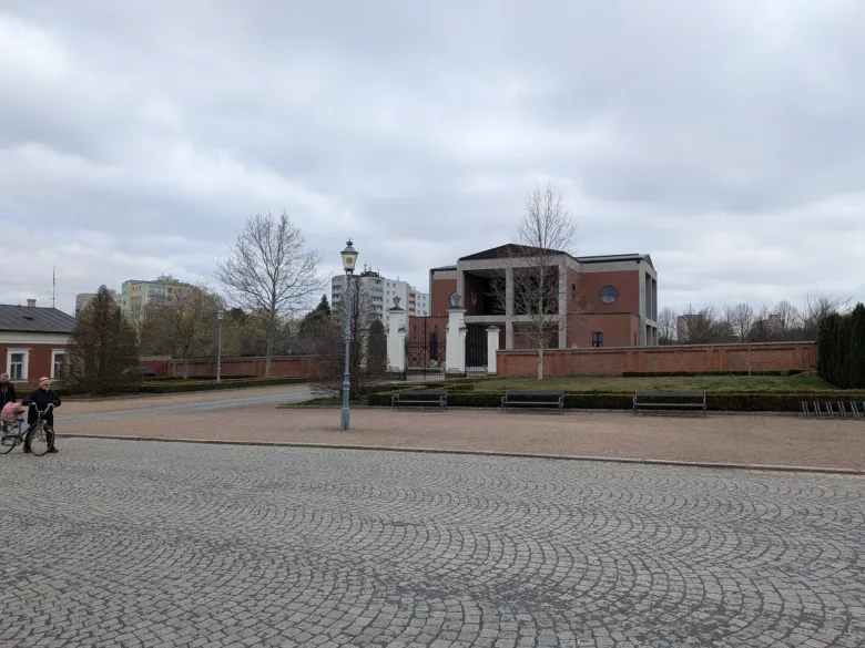 Exteriér smuteční síně v Opavě s dlažbou a okolní zelení.