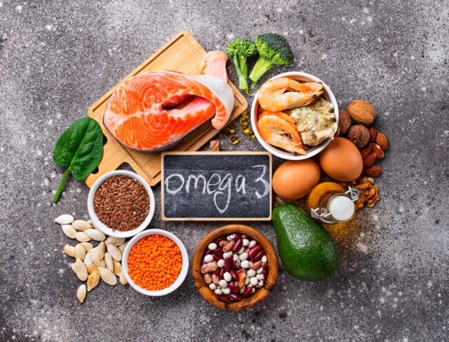 Různé potraviny bohaté na omega-3 jako losos a vaječné skořápky.