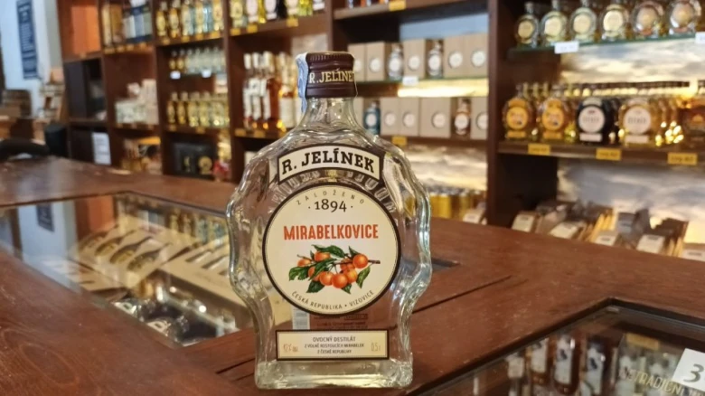 Fotka lahve likéru Mirabelka v obchodě s alkoholem.