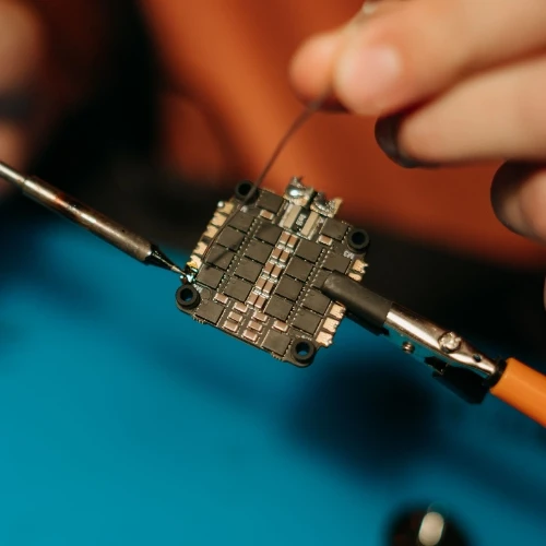 Ruční pájení elektronického součástku s cínem pomocí železa.