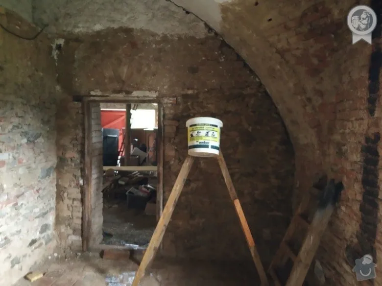 Interiér domu v rekonstrukci s viditelnými nástroji a nádobou na barvu pro plánování obnovy.