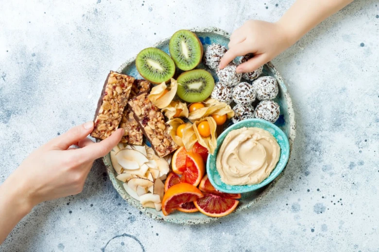 Zdravé večerní mlsání: kiwi, sušená meruňka, citrusy a energetické tyčinky.