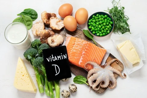Různá jídla bohatá na vitamín D jako losos, vejce a houby.