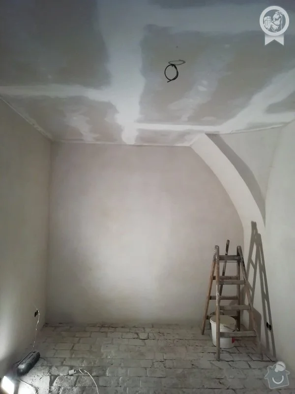 Průběh rekonstrukce interiéru s nástroji a omítkou na stěnách.