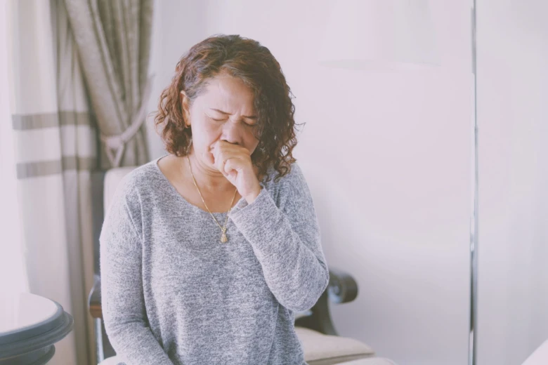 Woman coughing indoors