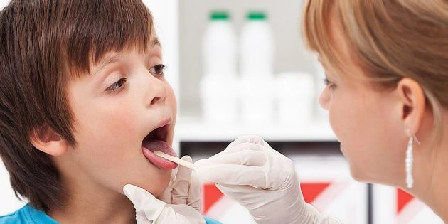 Dětský lékař provádí test na hrdlo nebo nosní dutinu.