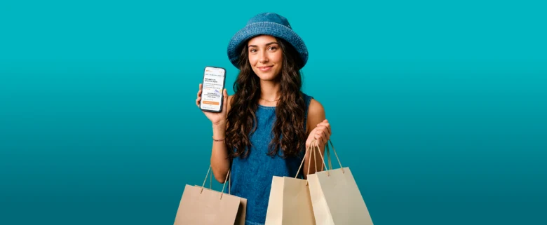 Žena s nákupními taškami drží chytrý telefon na modrém pozadí.