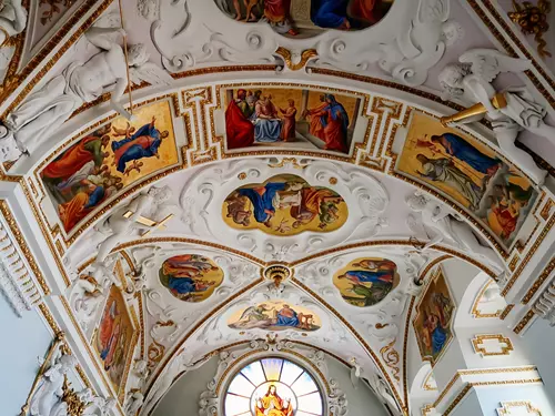 Vnitřek kostela s malbami na stropě.