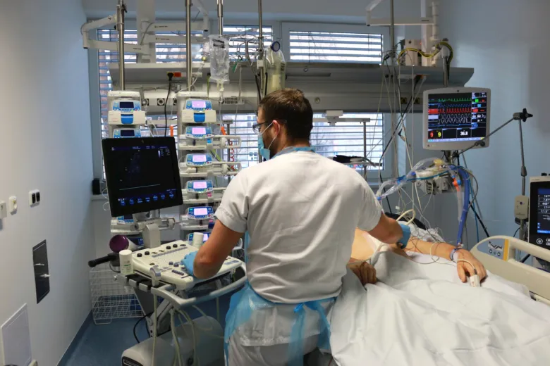 Lékař v nemocničním pokoji s monitorovaným pacientem