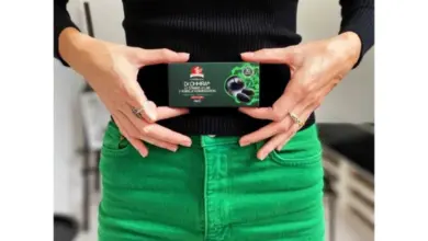 Žena drží krabičku s probiotiky před pasem.