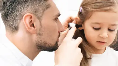 Lékař zkoumá ucho dítěte pomocí otoskopu.