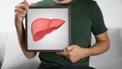 Muž drží rámeček s ilustrací lidského jatra.