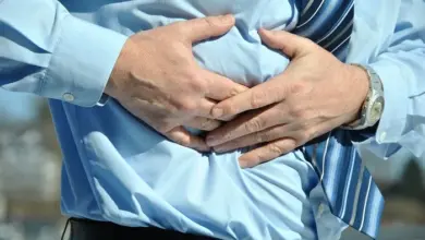 Muž drží břicho v bolesti kvůli průjmům.