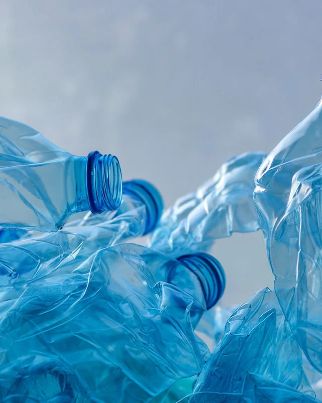 Zkrácené modré plastové lahve připravené k recyklaci.