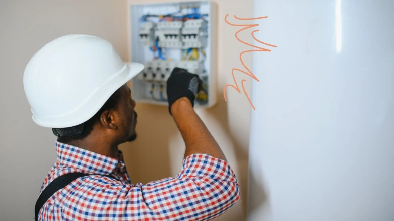 Elektrikář upravuje domovní rozvaděč s pojistkami.