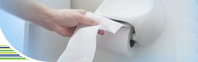 Ruka drží toaletní papír, který je součástí hygienických postupů.