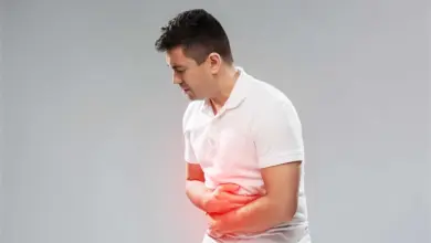 Muž drží břicho v bolesti kvůli žaludečnímu vředu.