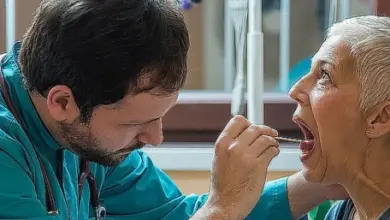Lékař vyšetřuje ústní dutinu seniora pomocí nástroje.