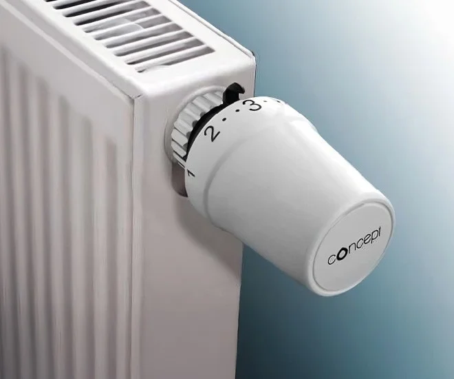Bílá termostatická hlavice na radiátoru s logem concept.