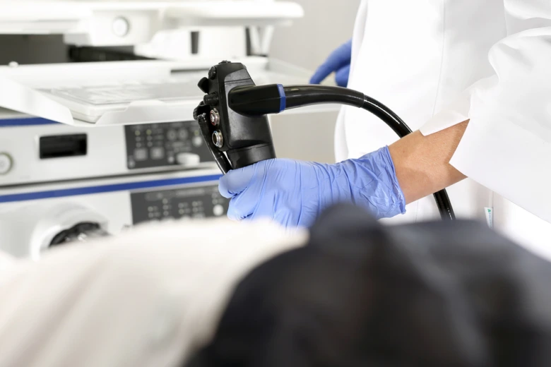 Lékař drží gastroskop při vyšetření žaludku pro vřed.