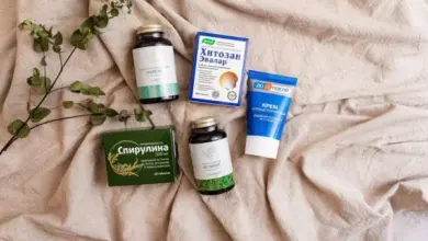 Přírodní produkty pro hemeroidy: bylinky, kapsle a krém na látkovém podkladě.