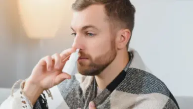 Muž používá nosní sprej pro léčbu zánětu nosohltanu.