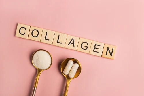 Dřevěné kostky s nápisem kolagen nad lžičkami s práškem.