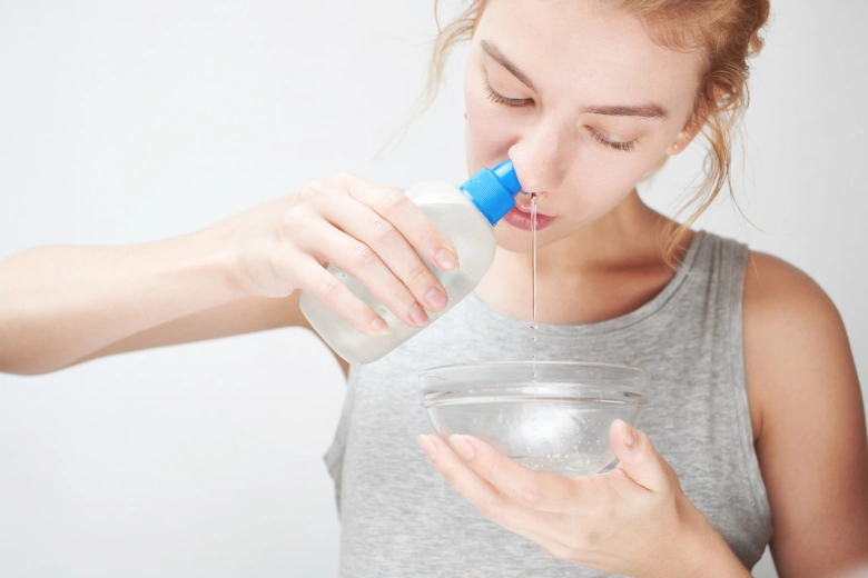 Woman rinsing nose with saline solution