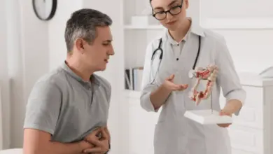Lékařka vysvětluje pacientovi stav střevního traktu pomocí modelu.