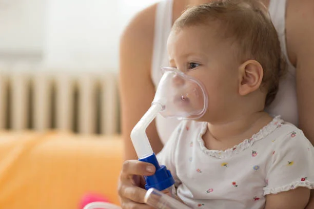 Dítě s maskou pro inhalační terapii při zánětu průdušek