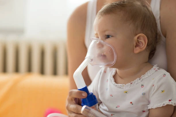 Dítě s maskou na inhalační léčbu bronchitidy
