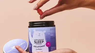 Ruka drží nádobku s vitamíny na spánek a bere žvýkačku.