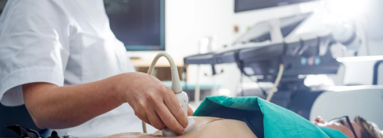 Lékař provádí ultrazvukové vyšetření břicha pacienta.