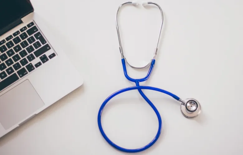 Stetoskop vedle notebooku pro diagnostiku zápalu plic.